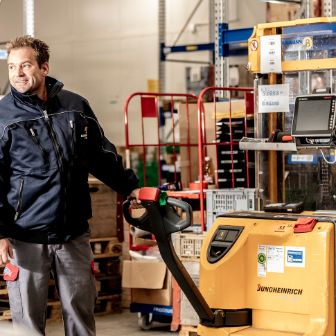 Das Bild zeigt einen Mitarbeiter der Logistik mit einem Stapler. Baumann Käse steht für die Logistik von der Käserei bis in den Laden.