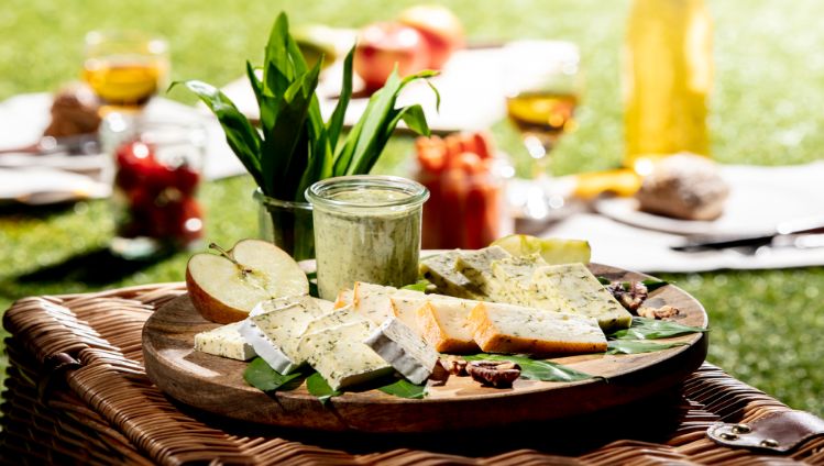 Frühlingshafte Käseplatte mit saisonalen Käsesorten wie Bärlauch-Brie, Bärlauch-Halbhartkäse, Kräuterbrie und Kräutermutschli. Im Chäsbueb kaufen.